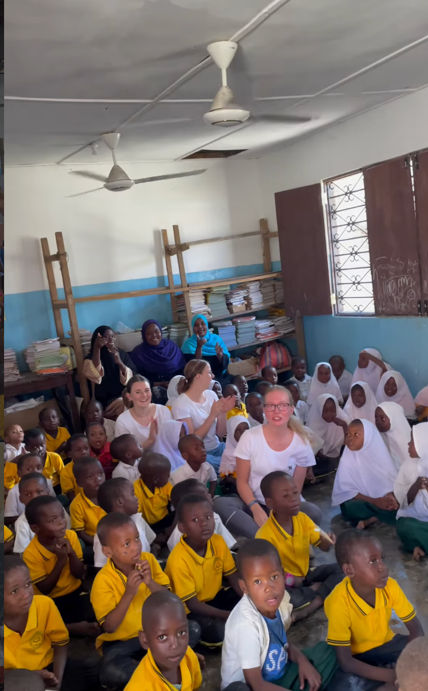 Volunteers with schoolchildren in a classroom at Shining Star Junior Academy